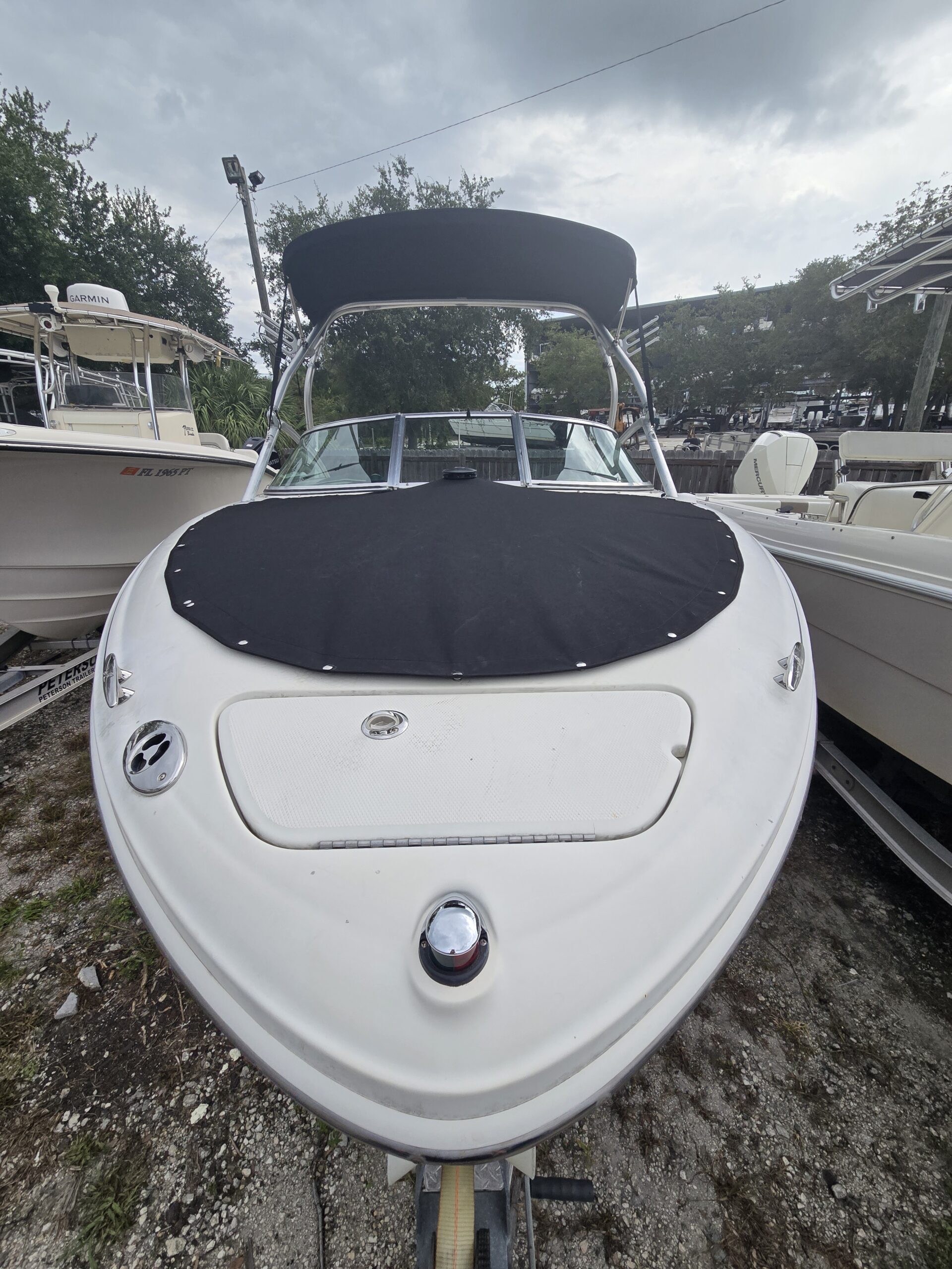 Fitted black bow cover and matching Bimini top on a white boat.