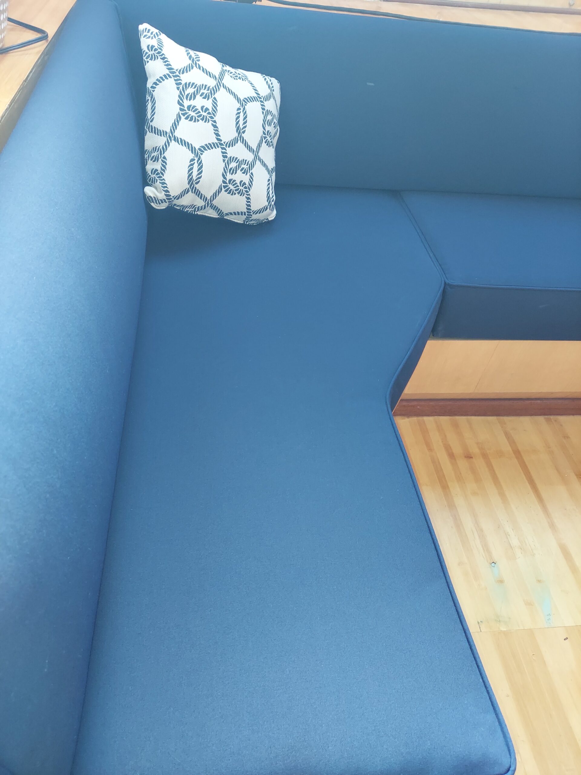 Custom blue cabin seating with fitted cushions and a patterned accent pillow.
