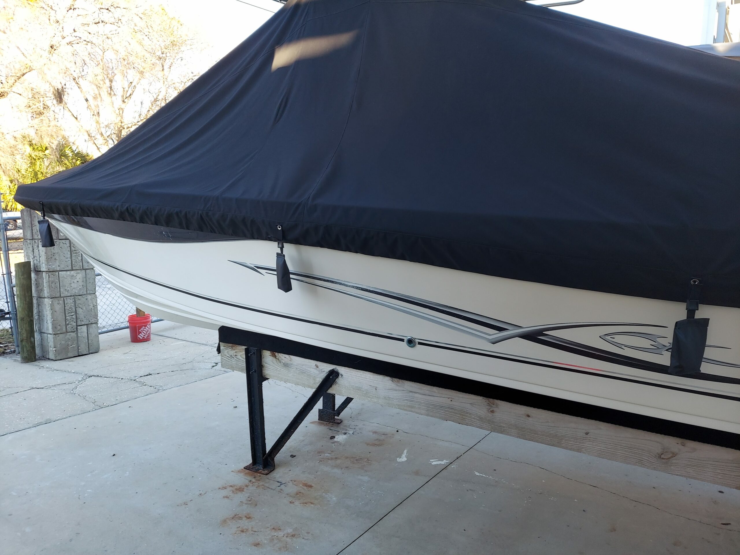 Fitted navy marine canvas boat cover secured around the hull.